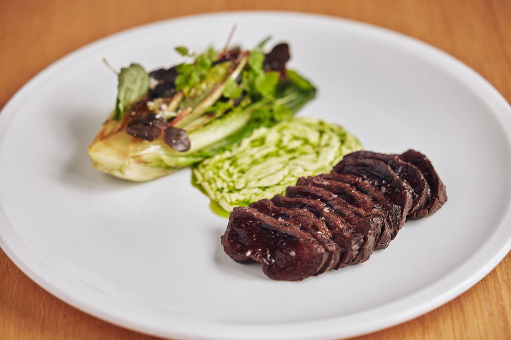 Hval med grillet hjertesalat, urter og syrnet fløte med pepperot og purreløk